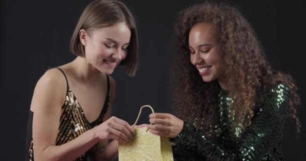 Jovens Mulheres Felizes Olhando Dentro Saco Compras Contra Fundo Escuro — Vídeo de Stock