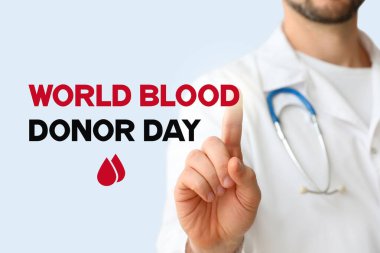 Erkek doktor arka planda sanal ekran kullanıyor. Dünya Kan Bağışı Günü