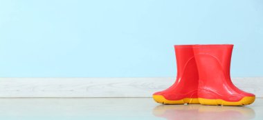 Renk arkaplanı üzerine lastik yağmur çizmeleri ve metin için boşluk