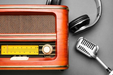 Gri arka planda mikrofon ve kulaklıklı Retro radyo alıcısı