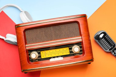 Renk arkaplanında mikrofon ve kulaklık olan eski radyo alıcısı