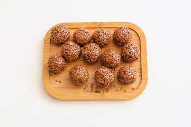 Beyaz arkaplanda lezzetli keten tohumu şekerleri olan tahta