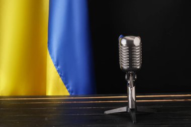 Koyu ahşap arka planda Ukrayna mikrofonu ve bayrağı