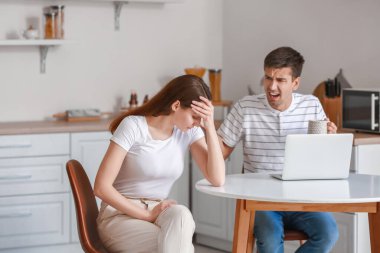 Genç adam mutfakta kız arkadaşına bağırıyor.