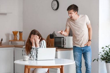 Genç adam mutfakta kız arkadaşına bağırıyor.