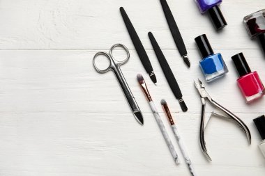 Manikür ekipmanları ve ojeler hafif ahşap arka planda