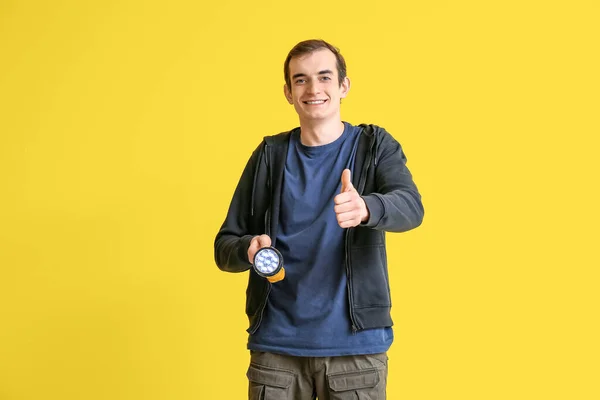 Young Man Led Torch Showing Thumb Yellow Background — Stock Photo, Image