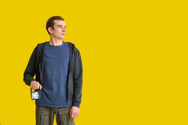 黄色の背景に懐中電灯を持つ若い男 — ストック写真