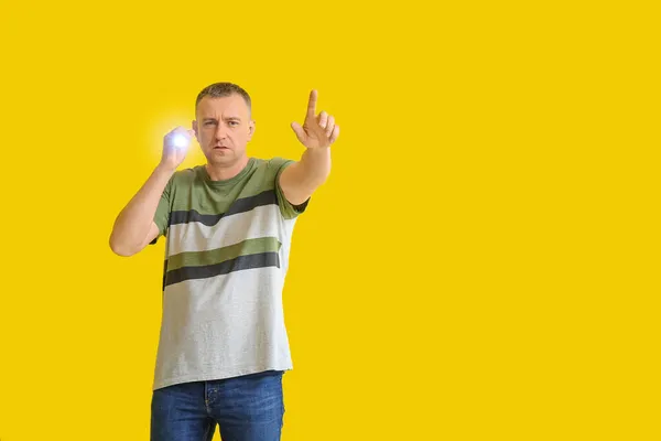 Mature Man Led Torch Pointing Something Yellow Background — Stock Photo, Image