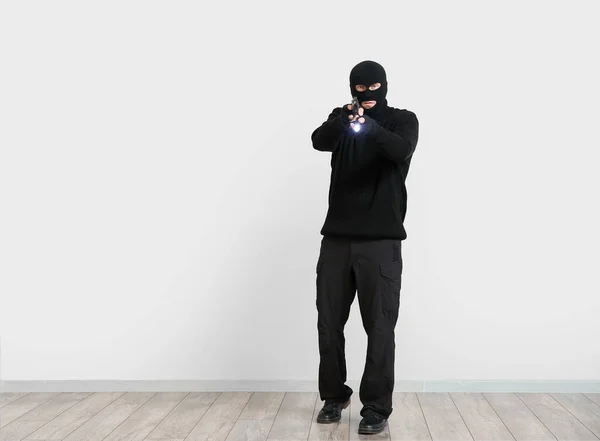 Man Crimineel Met Zaklamp Pistool Buurt Van Lichtmuur — Stockfoto