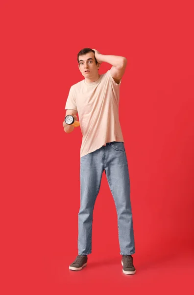 Schockierter Junger Mann Mit Led Taschenlampe Auf Rotem Hintergrund — Stockfoto