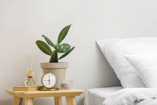 目覚まし時計とテーブルの上の観葉植物とスタイリッシュなベッドルームの部屋のインテリア — ストック写真
