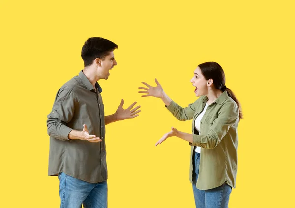 Pareja Joven Discutiendo Sobre Fondo Amarillo —  Fotos de Stock