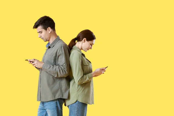 Quarreled Young Couple Using Mobile Phones Yellow Background — Stock Photo, Image