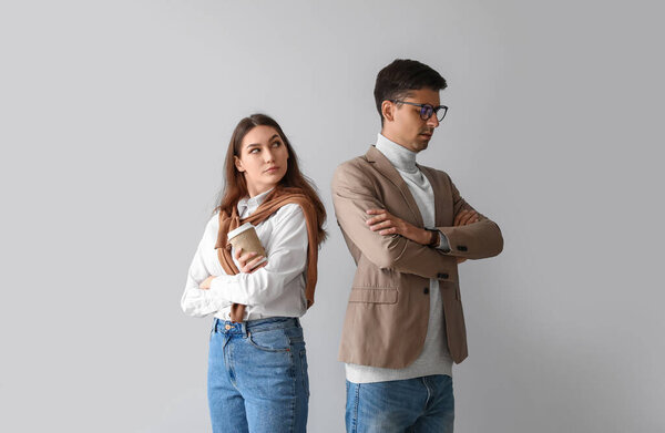 Quarreled young couple on light background