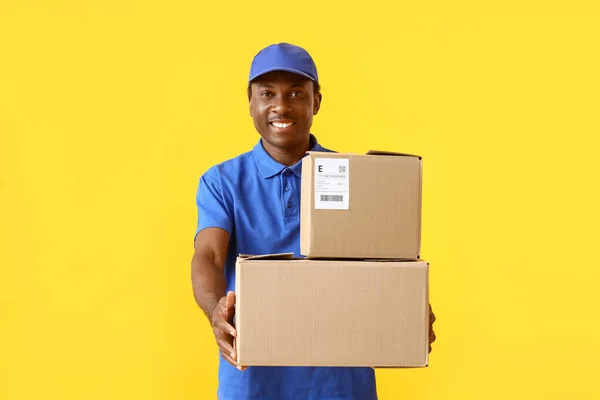 Repartidor Afroamericano Con Paquetes Sobre Fondo Color —  Fotos de Stock