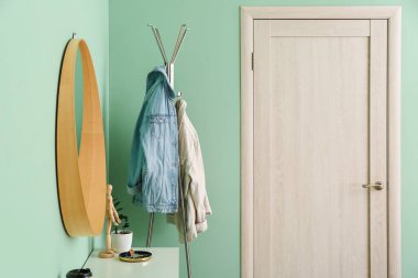 Koridordaki kapının yanında ceketli bir askı.