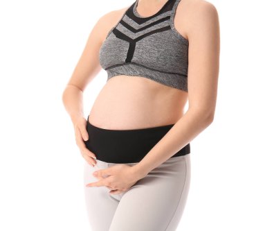 Beyaz arka planda genç ve güzel hamile bir kadın.