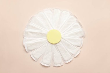 Chamomile flower made of menstrual pads on color background clipart