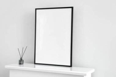 Işık duvarının yanındaki şömine rafında sazlık dağıtıcı olan boş çerçeve