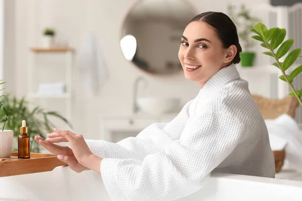 Mooie Vrouw Met Fles Etherische Olie Zitten Badkamer — Stockfoto