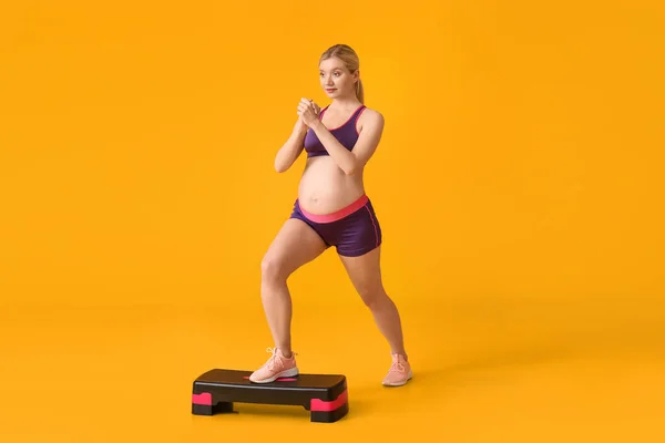 Young Pregnant Woman Training Aerobic Stepper Yellow Background — Stock Photo, Image