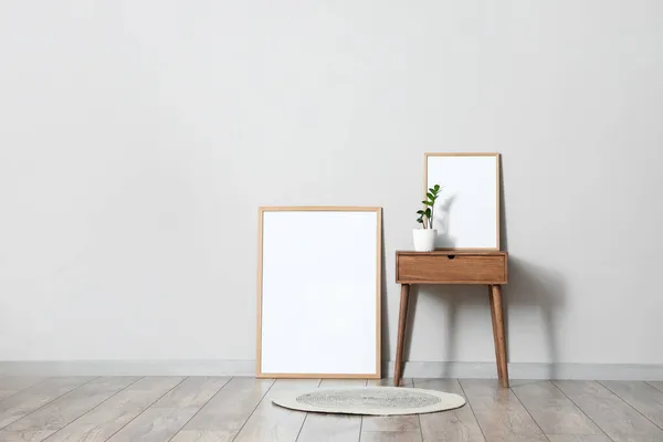 Wooden Table Flowerpot Blank Frames Light Wall — Stock Photo, Image