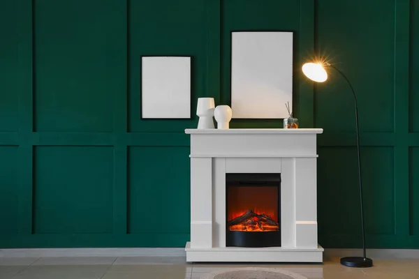 光るランプ 緑の壁にぶら下がっている空白のフレームと暖炉 — ストック写真
