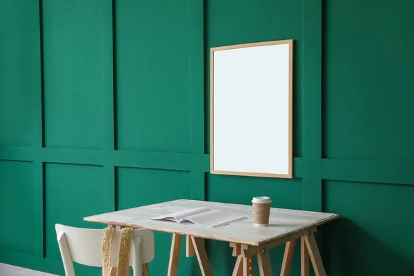 Yeşil Duvarda Bir Fincan Kahve Boş Çerçeve Asılı Modern Işyeri — Stok fotoğraf