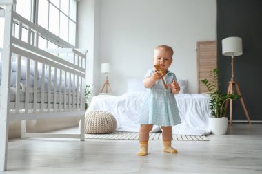 Çıngıraklı tatlı kız, yatak odasında yürümeyi öğreniyor.