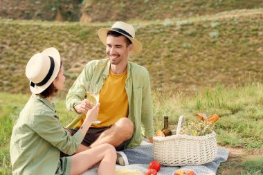 Mutlu genç çift dağlarda romantik piknik yapıyor.