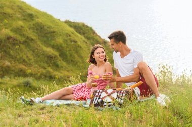 Mutlu genç çift dağlarda romantik piknik yapıyor.