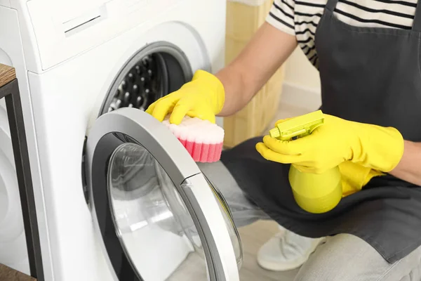 욕실에서 스폰지를 사용하여 세탁기를 청소하는 젊은이 벽장을 청소하는 — 스톡 사진