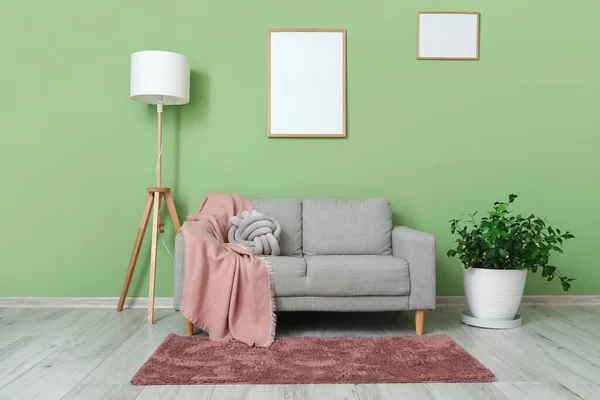 Grijze Bank Met Lamp Blanco Frame Hangend Aan Groene Muur — Stockfoto