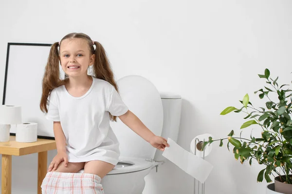 小さな女の子座ってトイレのボウルにバスルーム — ストック写真