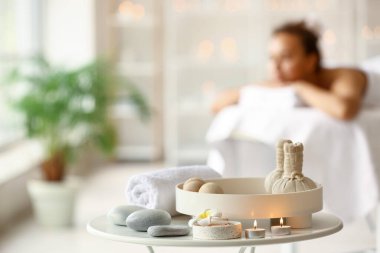 Spa salonundaki masasında bitki torbaları olan güzel bir spa kompozisyonu.