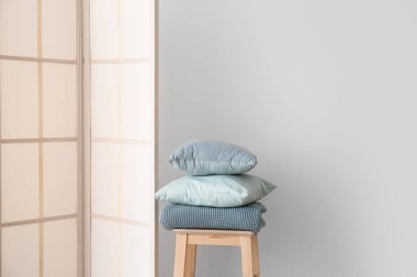 Duvar arkasının yanındaki taburede ve yastıklarda şık katlama ekranı