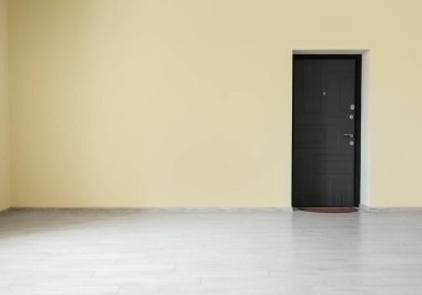 Siyah kapılı boş bej duvar manzarası