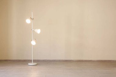 Büyük odadaki ışık duvarının yanında modern parlayan lamba.