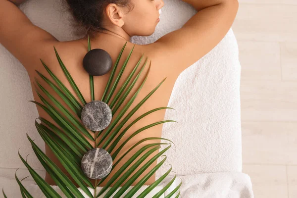 Young African American Woman Palm Leaf Stones Lying Couch Spa — Stock Photo, Image
