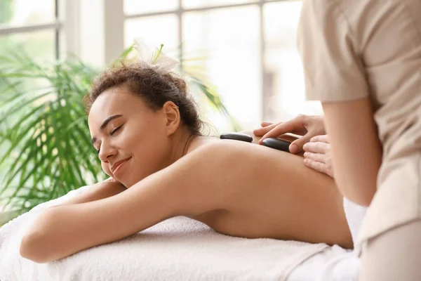 Jovem Afro Americana Recebendo Massagem Por Terapeuta Com Pedras Spa — Fotografia de Stock