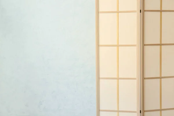 Stylish folding screen near wall in room interior