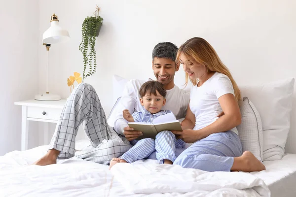 快乐的父母在卧室为他们的小儿子读书 — 图库照片
