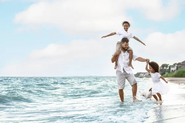 Szczęśliwa Rodzina Uroczym Psem Plaży Morskiej — Zdjęcie stockowe