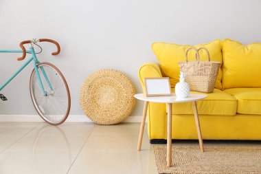 Sarı kanepeli ve bisikletli aydınlık oturma odasının içi