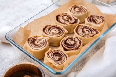 Beyaz arkaplanda pişmemiş tarçınlı rulo pişirme