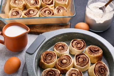 Pişmemiş tarçınlı çörekleri siyah beyaz arka planda pişirmek, yakın plan.