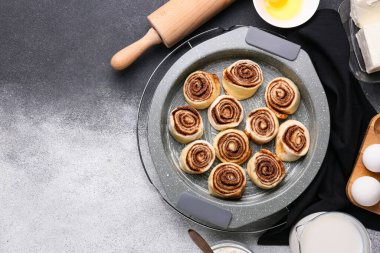 Siyah ve beyaz arka planda pişmemiş tarçınlı börek pişirme tabağı