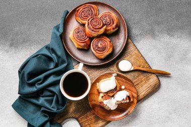 Lezzetli tarçınlı tabaklar ve arkaplanda bir fincan kahve.