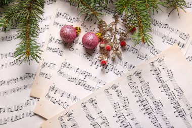Rowan 'la Noel baloları ve nota kağıtlarında köknar dalları.